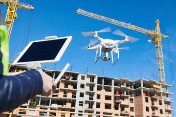 Wall Mural - drone operated by construction female worker on building site