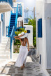 Attraktive Touristin läuft durch die weißen Gassen von Mykonos Stadt, Griechenland