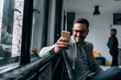 © bnenin - Cheerful businessman reading a text message in the meeting room. Close-up.