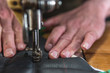 © Sergey - Sewing process of the leather belt. old Man's hands behind sewing. Leather workshop. textile vintage sewing industrial