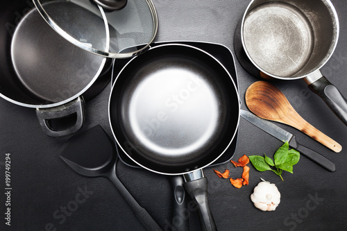 Cuadros en Lienzo Top view frying pan and pot on black leather table image for cooking background and food design background