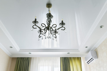 Beautiful iron chandelier of bronze color. The forged chandelier on the ceiling