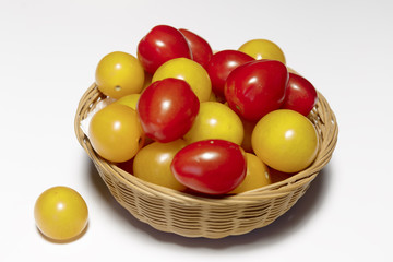 Wall Mural - Raw multicolored cherry tomatoes in the dish closeup, ready to eat, isolated on white, vegan food.