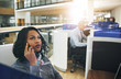 © Flamingo Images - Dreamy black woman talking smartphone in office