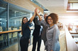 © Flamingo Images - Multiethnic business people giving high five in office