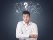 © ra2 studio - Young casual businessman with white question marks above his head