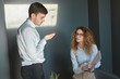 © Anatoliy Karlyuk - Horizontal shot of angry female boss wearing eyeglasses standing at office, holding papers in her hands, demanding explanation from male employee who made mistake in annual financial report