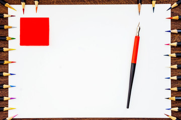 Frame from school supplies on a white background. In the center is a pen.