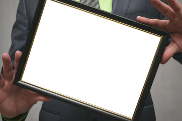 Diploma certificate of best worker or manager mock up. Businessman holding in hands a blank photo frame isolated on gray background. Close up photo.