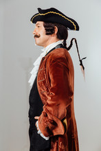 Mustachioed Eccentric Man In The Vintage Clothes Of The Baron. Hat Tricorn, Brown Jacket.