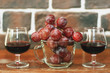 © Sergey - two glasses of wine and a cup of grapes by the brick wall