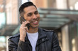 © blvdone - Hispanic man in city talking on cell phone