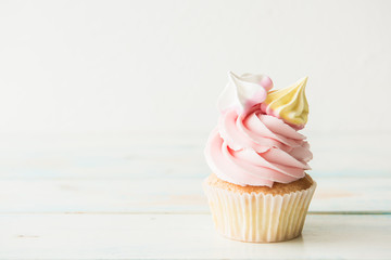 One cupcake on a wooden table. Copy space