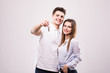 © F8  \ Suport Ukraine - Joyful young couple with a pair of keys isolated on white