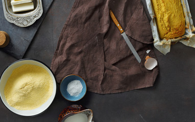 Wall Mural - Frame of raw ingredients for cooking corn bread on dark background top view