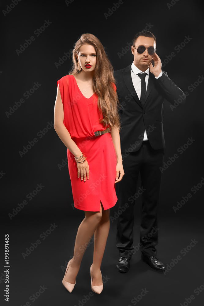 Famous celebrity with bodyguard on dark background