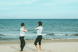 © Rafa - Young girls practicing yoga by the sea or beach.
