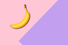 Creative Flat Lay Of Juicy Banana On Bright Pink And Violet Background Top View. Abstract Background In Pop Art Style. Minimal Fashion Art