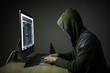 © F8  \ Suport Ukraine - A hacker in a hood on a dark background hacking computer networks in dark room
