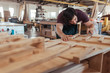 © mavoimages - Skilled craftsman hand sanding pieces of wood in his workshop