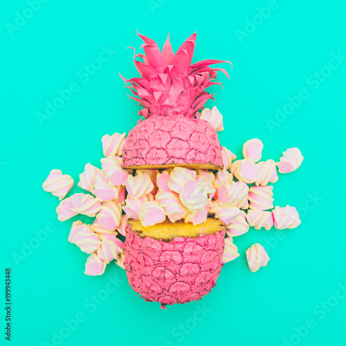Fotografia, Obraz two painted in pink color halfs of the pineapple of which fall marshmallow on turquoise background