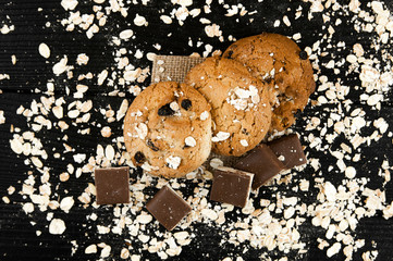 Homemade cookies and chocolate on a black vintage table. Tasty cookies and biscuits. Close-up of cookies.Wooden textured table.