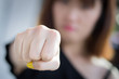 angry aggressive woman punching her fist; angry upset frustrated aggressive woman punching at you; martial art, self defense, Muay Thai, Karate, Kungfu, MMA street fight concept; punching hand closeup