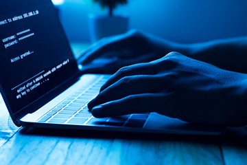 a computer programmer or hacker prints a code on a laptop keyboard to break into a secret organizati