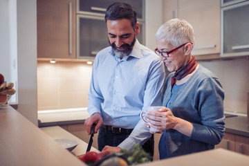 Wall Mural - Romantic mature couple cooking together in the kitchen