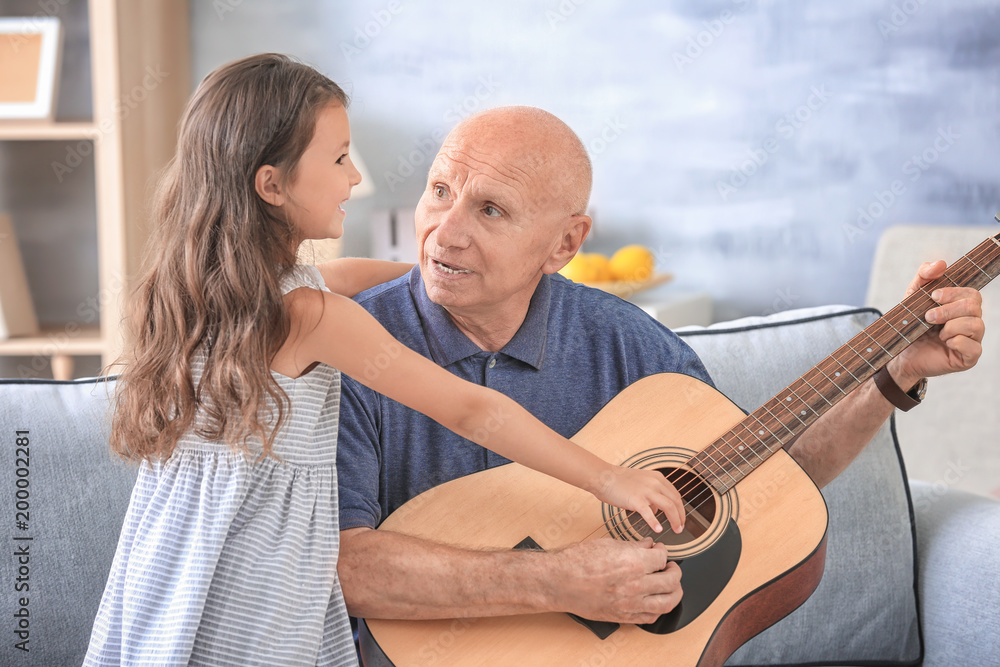Senior man with his granddaughter at home