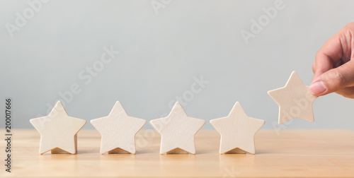 Cuadros en Lienzo Hand putting wooden five star shape on table