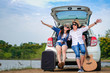 © Anusorn - Couple of traveler sitting on hatchback of car and enjoy for view of nature near the lake during holiday.Young couple tourist enjoying on vacation.