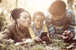 © Mladen - Happy African American little girl taking self picture in park of parents and her.