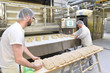 Lebensmittelindustrie: Großbäckerei - Arbeiter backen Brot // Food industry: Bakery - workers baking bread 