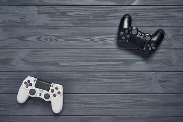 Wall Mural - Computer game competition. Gaming concept. Top view of two joysticks on wooden table with copy space