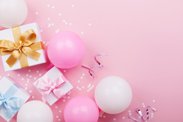 Wall Mural - Pink table with balloons, gift or present box and confetti top view. Flat lay. Composition for birthday or party theme.