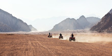 High Speed Race Of Several People Riding Quad Bikes In Desert