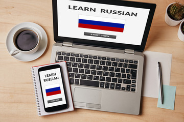 Wall Mural - learn russian concept on laptop and smartphone screen over wooden table. all screen content is desig