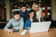 © Aleksandr - Group of college students studying in the school library, a girl and a boy are using a laptop and connecting to internet