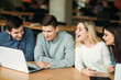 © Aleksandr - Group of college students studying in the school library, a girl and a boy are using a laptop and connecting to internet