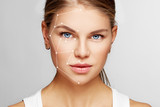 Fototapeta  - Skin care and technology. Portrait of beautiful woman face with drawn massage lines. 
