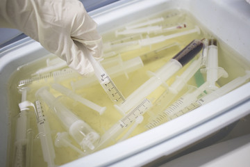 medical trays in a chemical solution for disposal of syringes