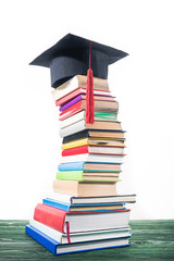 Wall Mural - Graduation cap on bent tower of stacked books