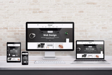 multiple display devices with modern flat design web site presentation. wooden desk and brick wall i