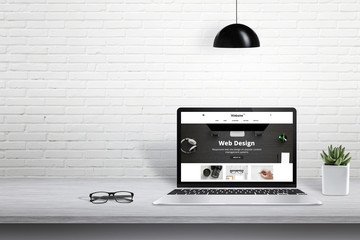 Aufkleber - Laptop with modern web site presentation. Free space for text beside on white brick wall.