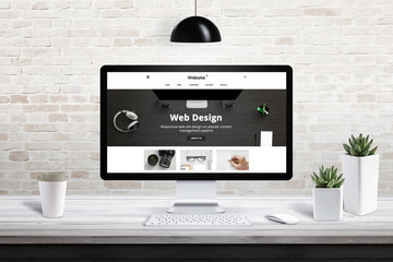 Poster - Responsive web site design presentation on computer display. Modern office interior with brick wall in background.
