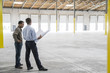 © Mint Images - Owner of new warehouse and architect going over blueprint of new interior layout