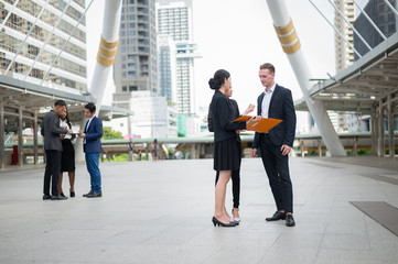 Group of business people standing in the city and discussing ideas for business future. multi culture of business people, African, Caucasian and Asian.