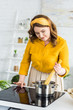 © LIGHTFIELD STUDIOS - beautiful woman putting pasta into pan with water at kitchen