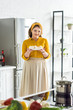 © LIGHTFIELD STUDIOS - smiling beautiful woman holding plate with mushrooms at kitchen